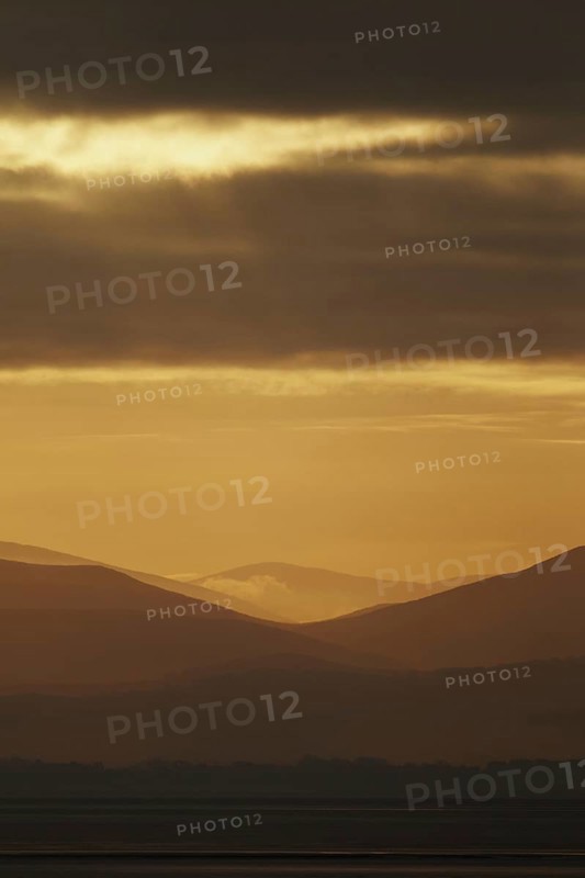 View across estuary to distant hills at sunrise