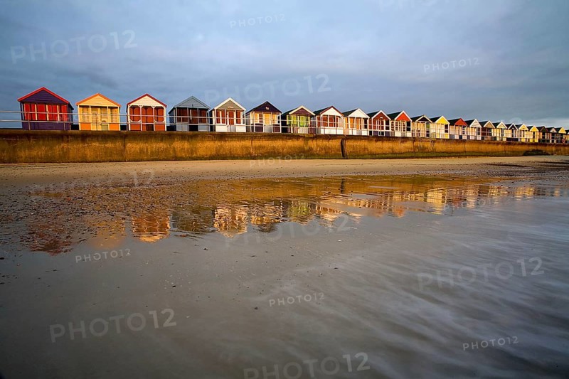 Beach huts on the seaside resort dyke at sunrise
