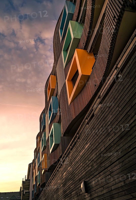 Wooden house with colourful windows in Golden Hour