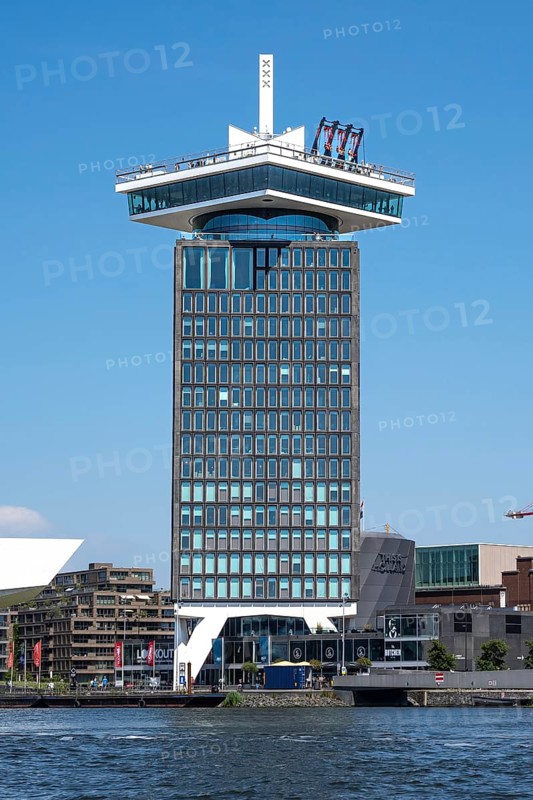 High-rise building with a swing on the roof by the city canals