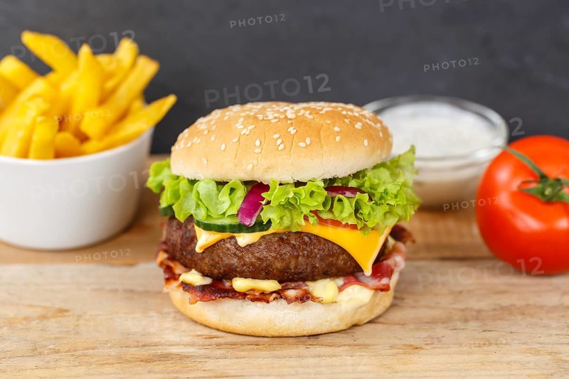Hamburger cheeseburger fast food meal menu with fries on wooden board in Stuttgart