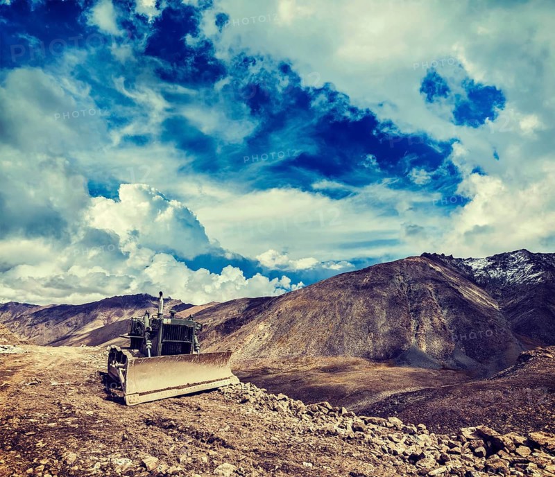 Vintage retro effect filtered hipster style travel image of Bulldozer on road in Himalayas. Ladakh