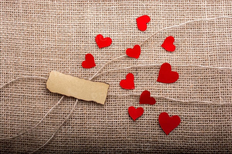 Love concept with heart shaped papers on linen threads