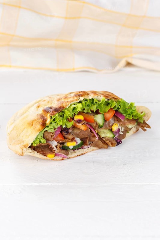 Doener Kebab Doner Kebap half fast food meal in pita bread on wooden board in Stuttgart