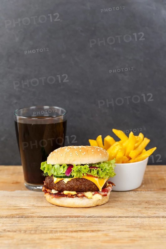 Hamburger cheeseburger fast food meal menu with fries and coke drink on wooden board in Stuttgart