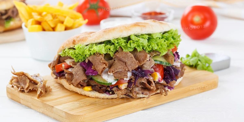 Doener Kebab Doner Kebap fast food meal in pita bread menu with fries on kitchen board Panorama in Stuttgart