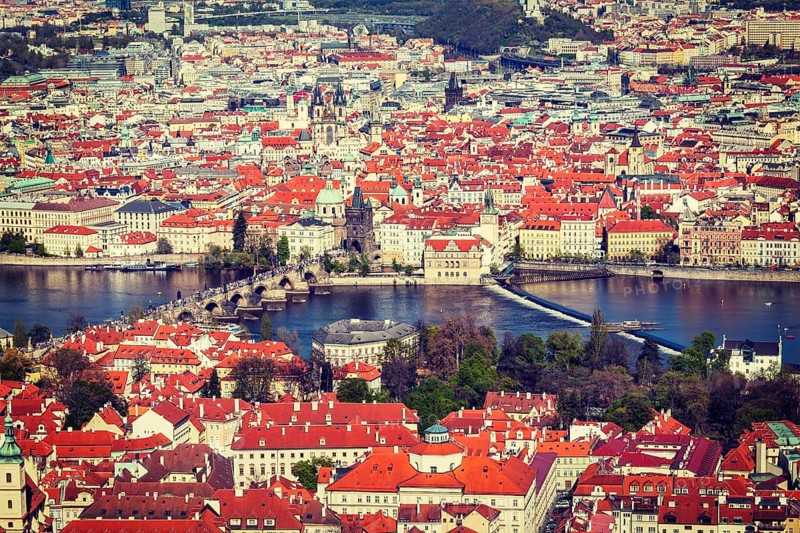 Vintage retro hipster style travel image of aerial view of Charles Bridge over Vltava river and Old city from Petrin hill Observation Tower. Prague