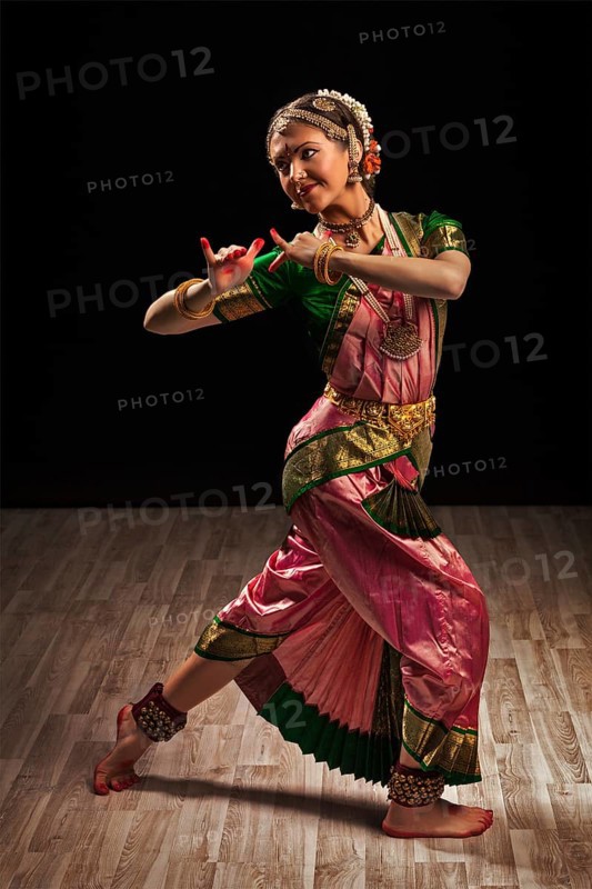 Young beautiful woman dancer exponent of Indian classical dance Bharatanatyam in Krishna pose