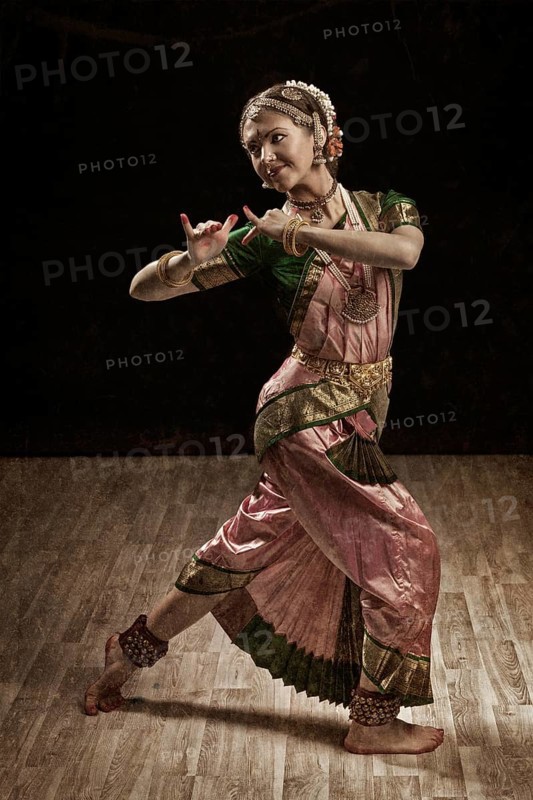 Vintage retro style image of young beautiful woman dancer exponent of Indian classical dance Bharatanatyam in Krishna pose
