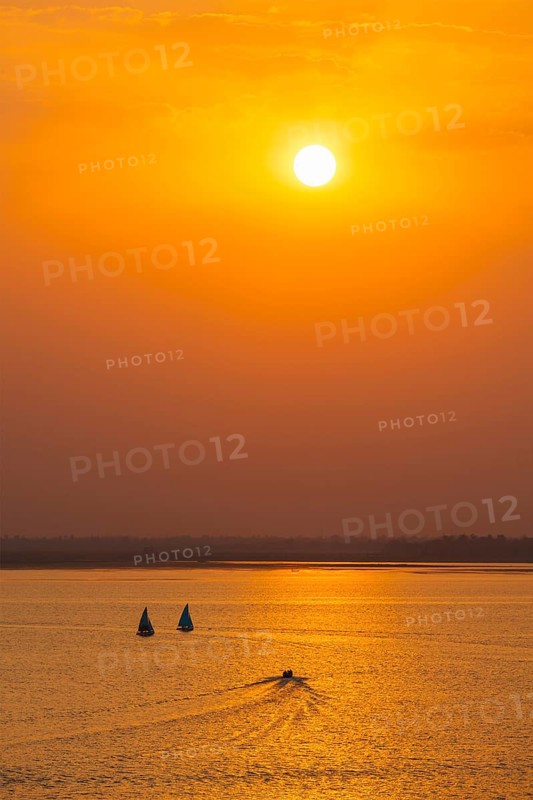 Yacht boats silhouettes in lake on sunset