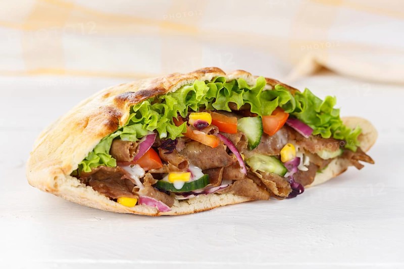 Doener Kebab Doner Kebap half fast food meal in pita bread on wooden board in Stuttgart