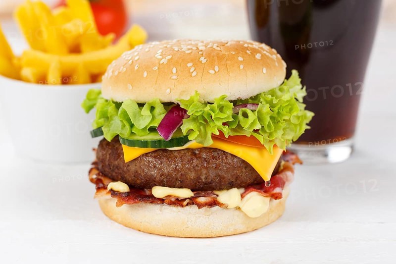 Hamburger cheeseburger fast food meal menu with fries and coke drink on wooden board in Stuttgart