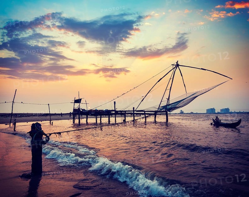 Vintage retro hipster style travel image of Kochi chinese fishnets on sunset. Fort Kochin