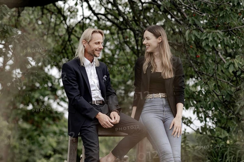 Man and woman talking on a wooden table in nature
