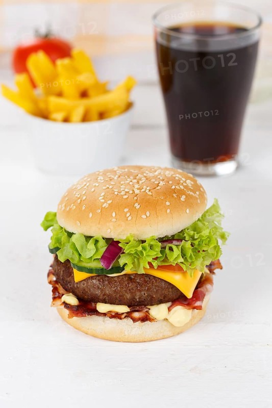 Hamburger cheeseburger fast food meal menu with fries and coke drink on wooden board in Stuttgart