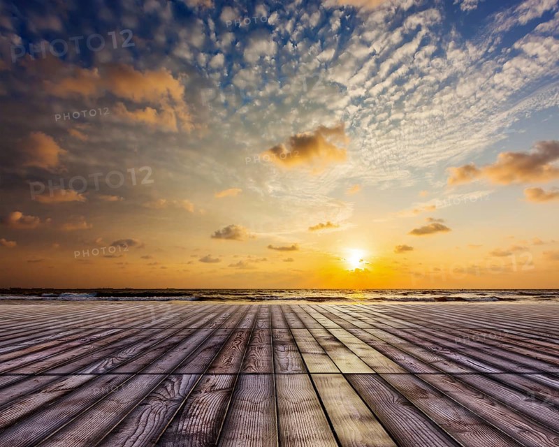 Wooden surface of planks pier under sunset dramatic sky