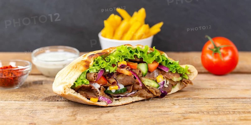 Doener Kebab Doner Kebap fast food meal in pita bread menu with fries on wooden board Panorama in Stuttgart