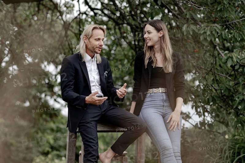 Man and woman talking on a wooden table in nature
