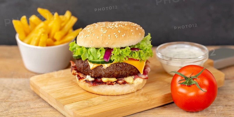 Hamburger cheeseburger fast food meal with fries on wooden board Panorama in Stuttgart