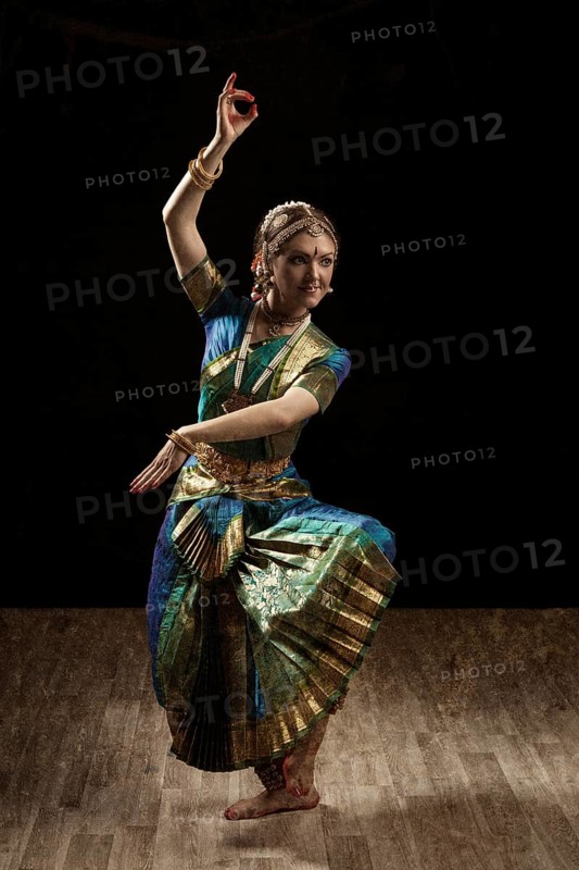 Vintage retro style image of young beautiful woman dancer exponent of Indian classical dance Bharatanatyam in Shiva pose