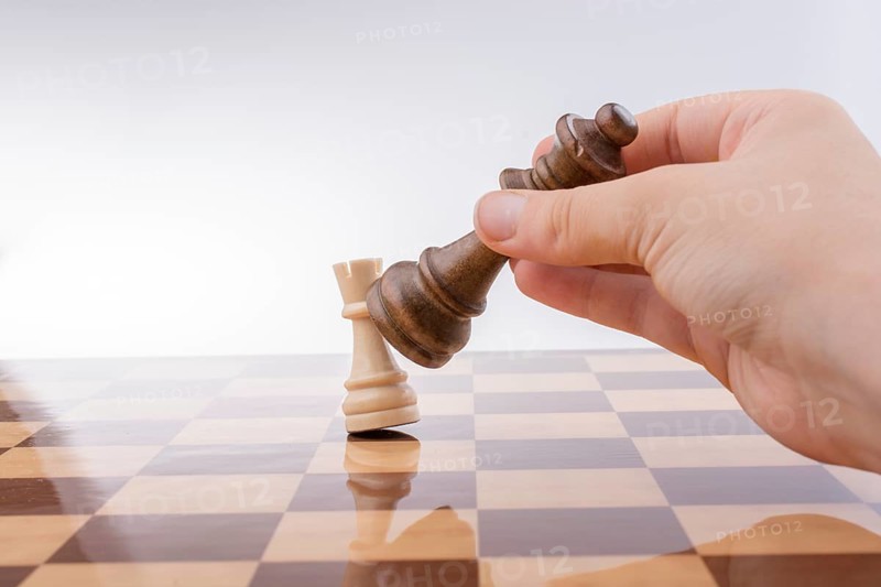 Person playing chess game making a move on board