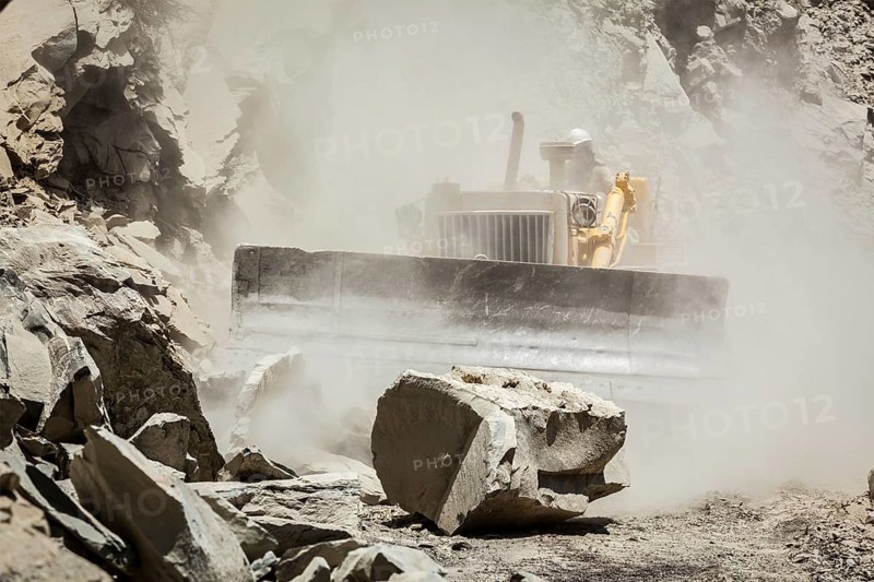 Bulldozer cleaning landslide from road in Himalayas. Himachal Pradesh