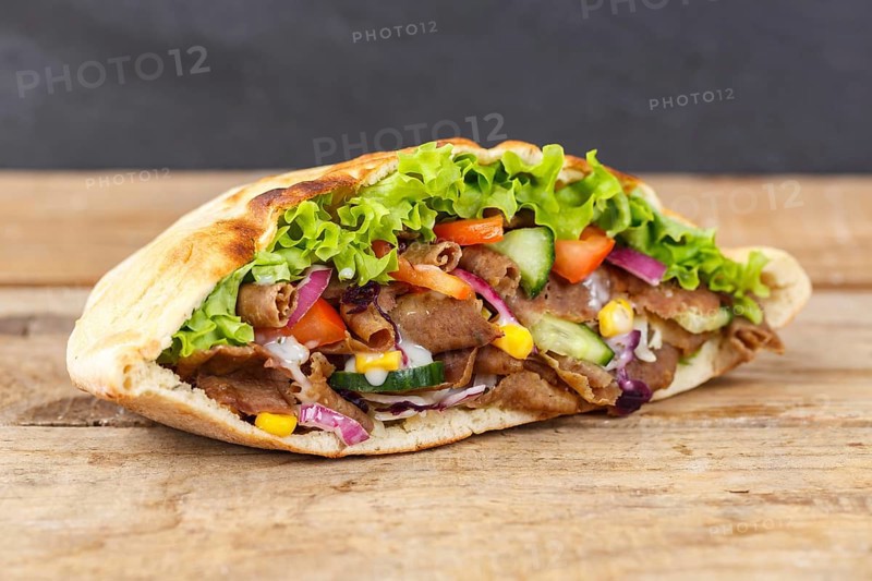Doener Kebab Doner Kebap fast food meal in pita bread on wooden board in Stuttgart