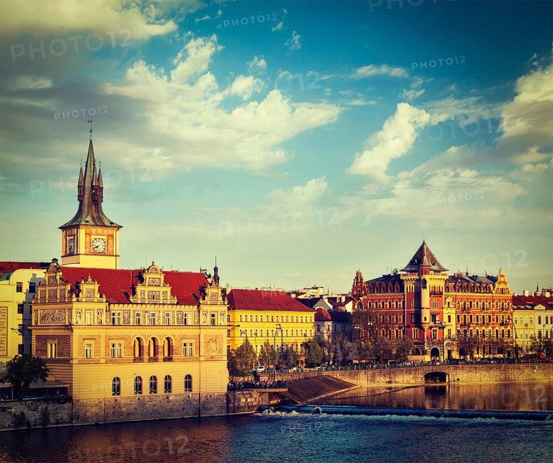 Vintage retro hipster style travel image of Prague Stare Mesto embankment view from Charles bridge on sunset. Prague
