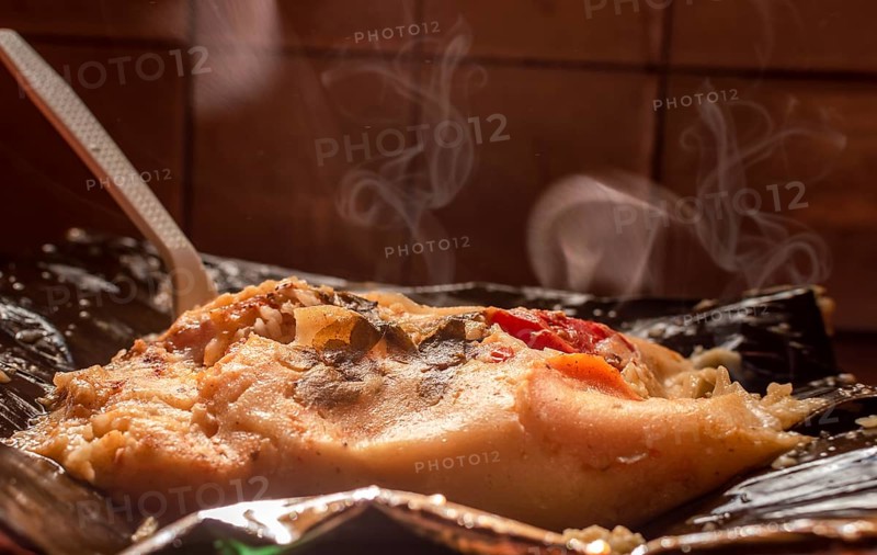 A freshly served traditional Nacatamal. Side view of Traditional Nacatamal served on banana leaf