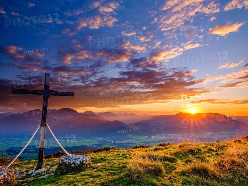 Summit cross of the Schlenken at sunset clouds