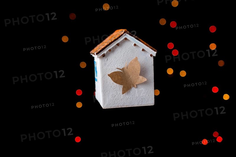 Paper butterfly on a Model house on a bokeh light