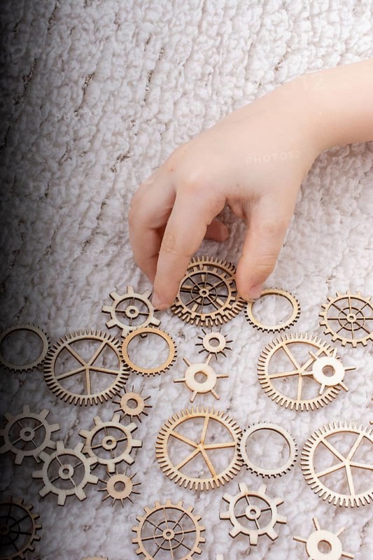 Hand holding gear wheels as the concept of mechanism