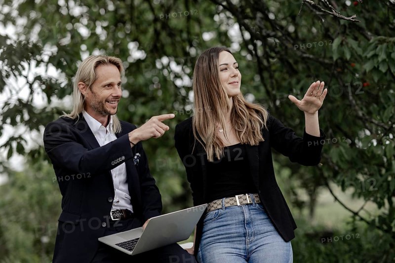 Man and woman talking on a wooden table in nature