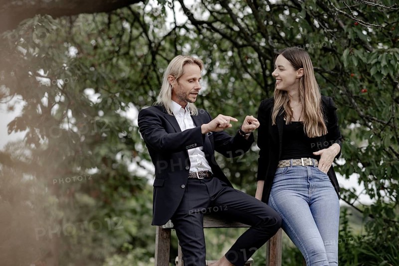 Man and woman talking on a wooden table in nature