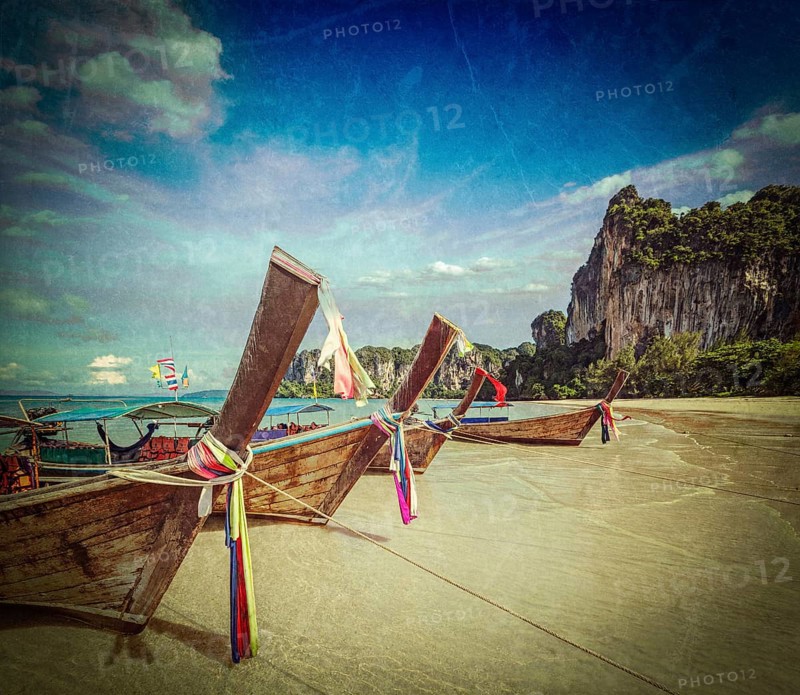 Vintage retro hipster style travel image of Long tail boats on tropical beach