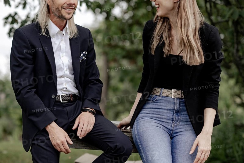 Man and woman talking on a wooden table in nature