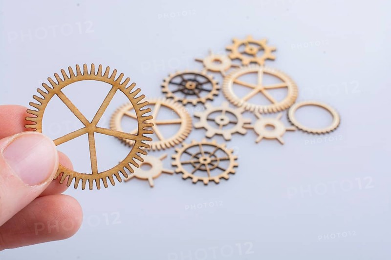 Hand holding gear wheels as the concept of mechanism
