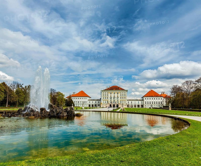Fountain in Grand Parterre Baroque garden and the rear view of the Nymphenburg Palace. Munich