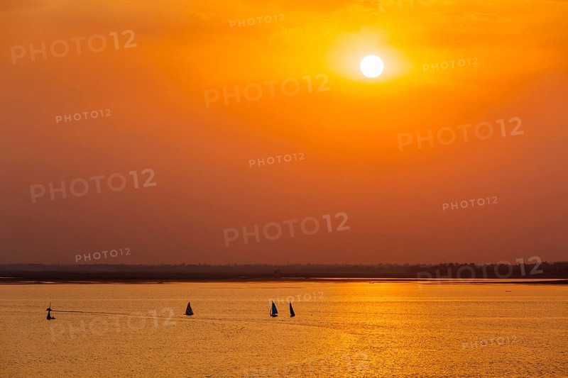 Yacht boats silhouettes in lake on sunset