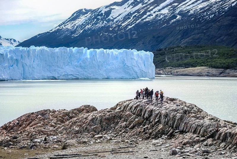 Travelers looking at Perito Moreno glacier located in Patagonia