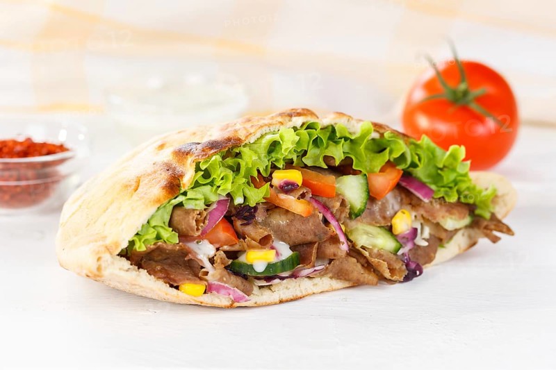 Doener Kebab Doner Kebap fast food meal in pita bread on wooden board in Stuttgart