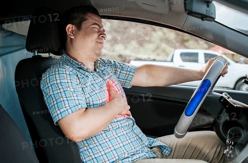 Suffering driver with chest pain. Male driver with chest pain in traffic. Person with heart attack while driving. Driver with chest pain. Driver's Heart Attack Concept