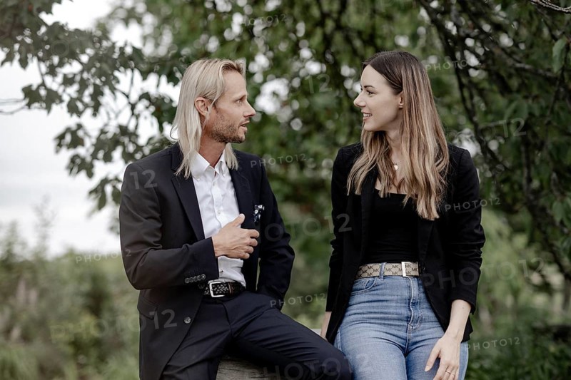 Man and woman talking on a wooden table in nature