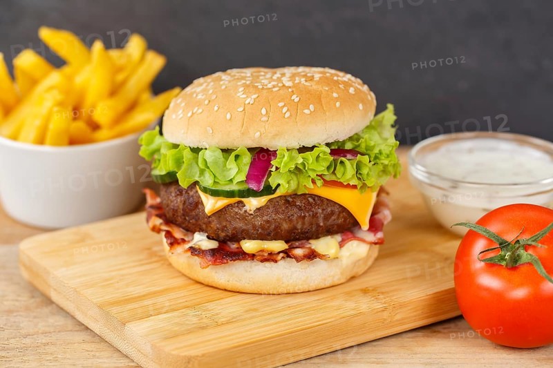 Hamburger cheeseburger fast food meal with fries on wooden board in Stuttgart