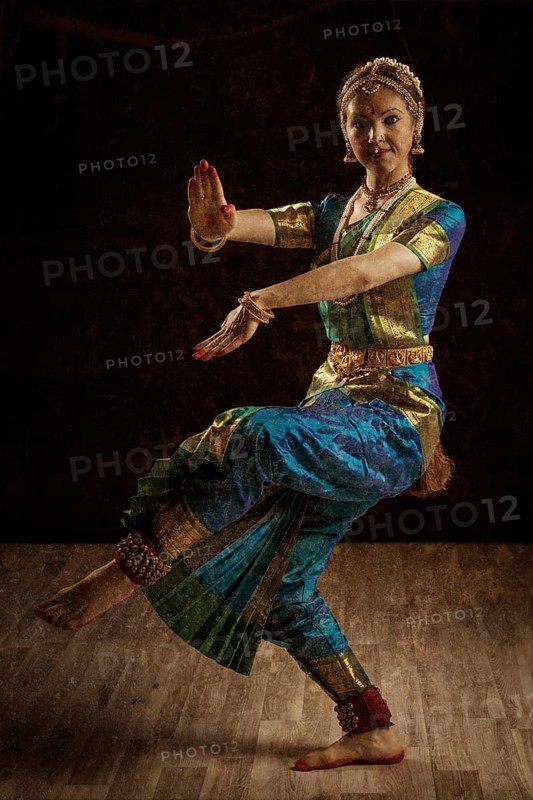 Vintage retro style image of young beautiful woman dancer exponent of Indian classical dance Bharatanatyam in Shiva pose