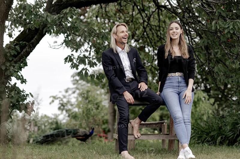 Man and woman talking on a wooden table in nature