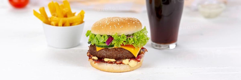 Hamburger cheeseburger fast food meal menu with fries and coke drink on wooden board Panorama in Stuttgart