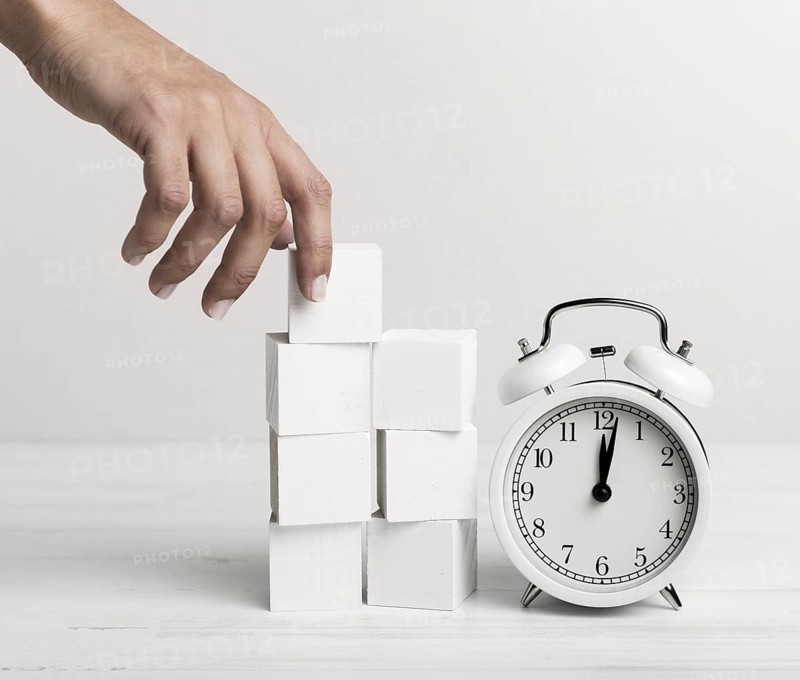 Hand putting white cubes clock