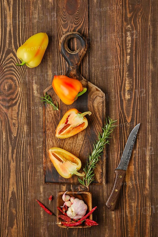 Overhead composition with sweet bell pepper on wooden cutting board