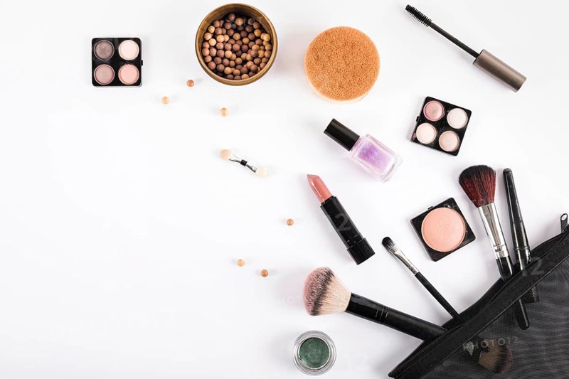 Elevated view makeup brushes cosmetics white backdrop